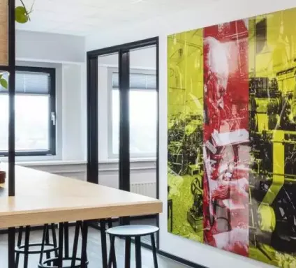 Gedeelte van een kantoorruimte met muur en hoge tafel met krukken