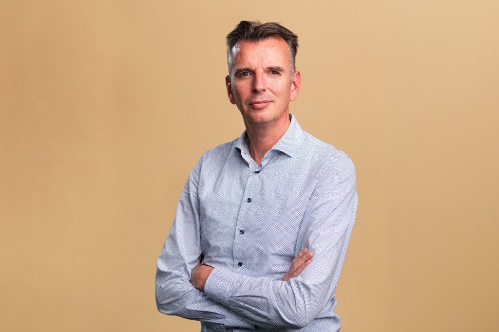 Foto van CFO Jan Boog van Lefebvre Sdu. Hij staat met een gekruiste armen en kijkt recht in de camera.